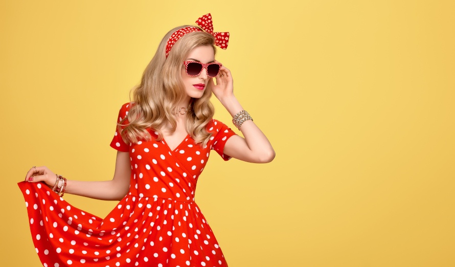 Stylizacja pin-up girl: czerwona sukienka w kropki, czerwona opaska i bransoletki