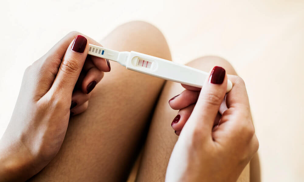 kobieta trzymająca pozytywny test ciążowy